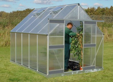 Une serre de jardin avec parois en verre idéale pour la culture des plantes